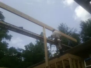 Carpenter setting a ridge beam over a new addition frame — Ice Dam Removal by Roofing Brothers in North Bend
