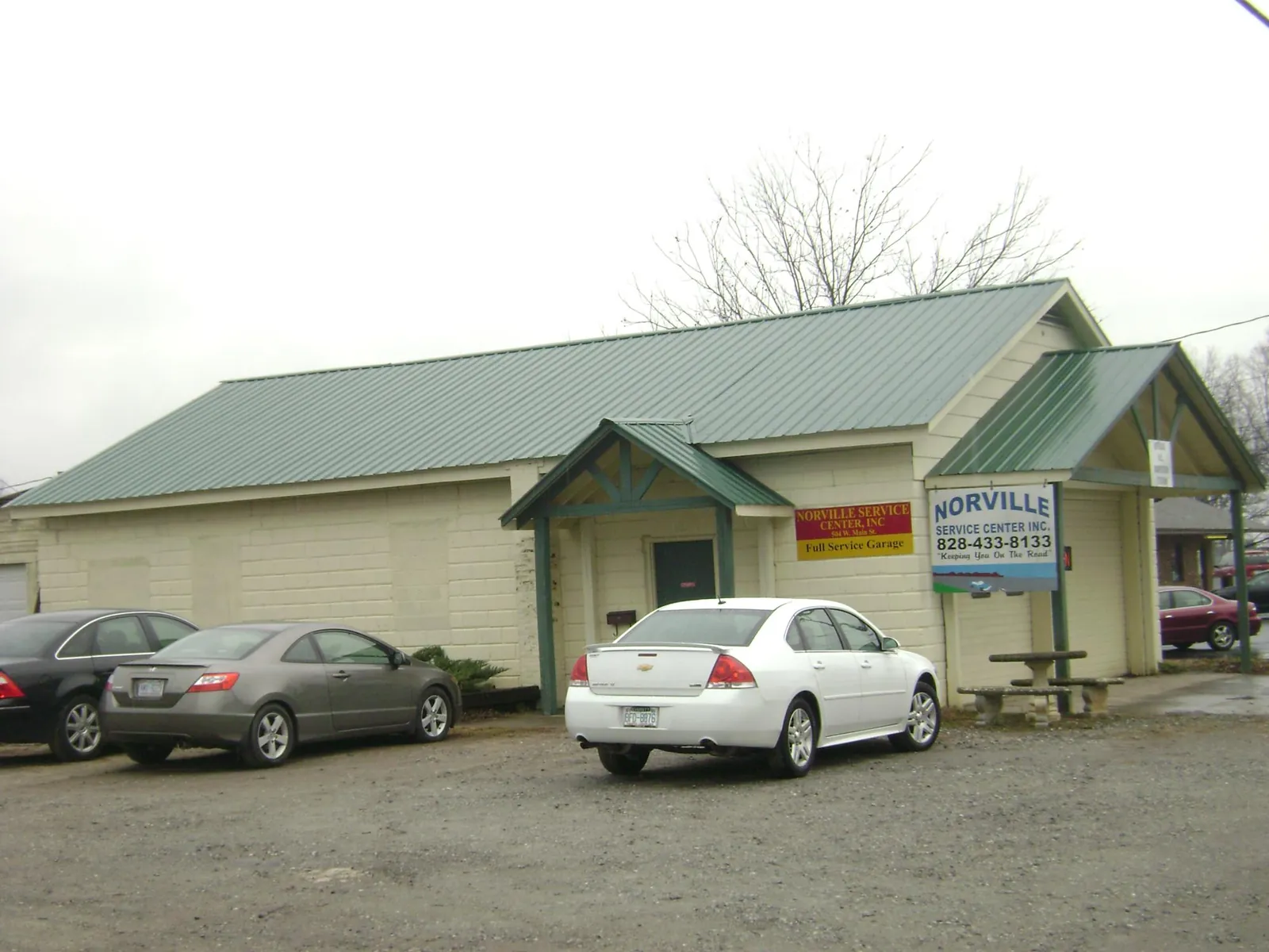 Green metal roof on a service garage with a covered entry in North Bend